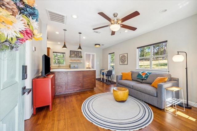 living area with visible vents, wood finished floors, and recessed lighting
