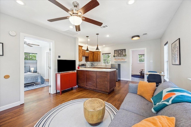 living room with plenty of natural light, a ceiling fan, recessed lighting, and dark wood finished floors