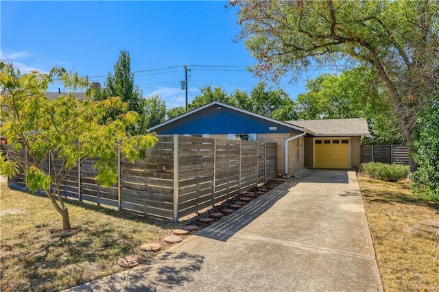 exterior space featuring concrete driveway and fence