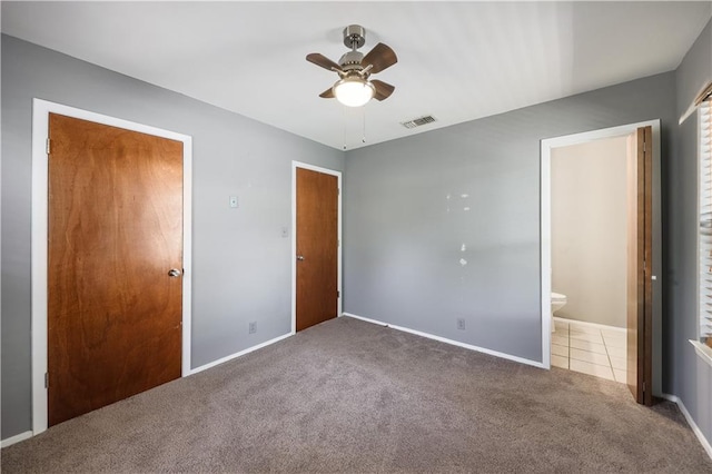unfurnished bedroom with visible vents, baseboards, carpet, a ceiling fan, and ensuite bath