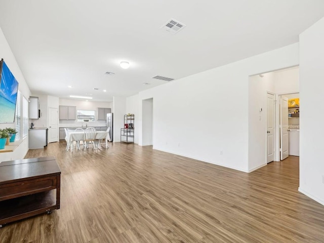 living room with baseboards, visible vents, and light wood-style floors