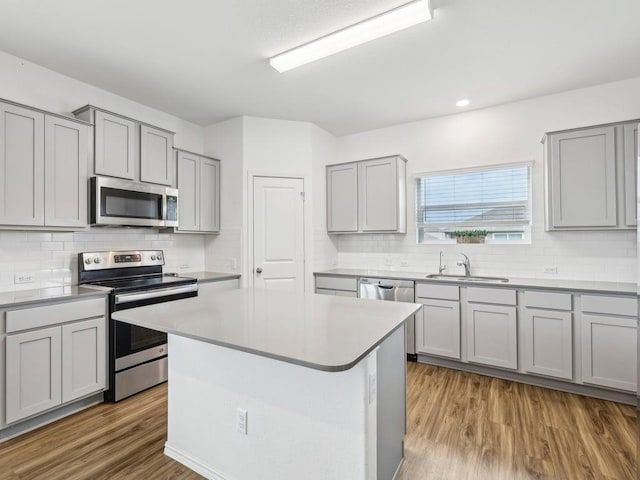 kitchen featuring a sink, gray cabinets, appliances with stainless steel finishes, and tasteful backsplash