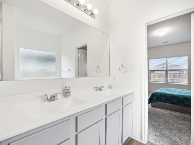 bathroom featuring double vanity, a sink, and visible vents