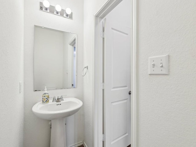 bathroom featuring a sink and a textured wall