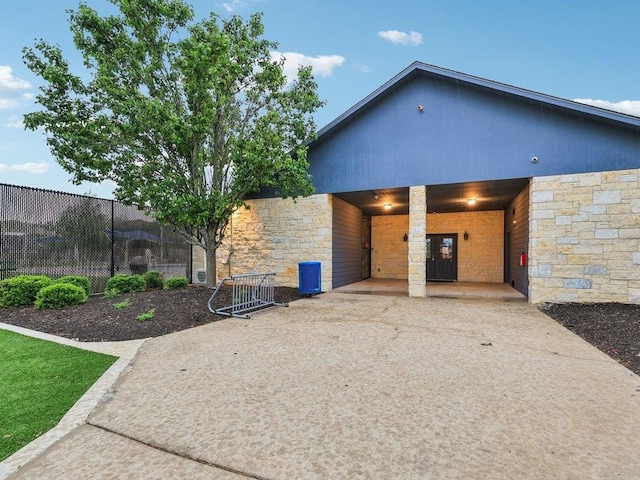 contemporary house featuring fence and stone siding