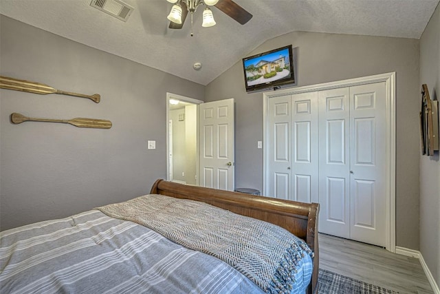 609 E Briarway Dr, Granite Shoals, TX 78654 - bedroom featuring wood finished floors, a closet, vaulted ceiling, visible vents, and a ceiling fan