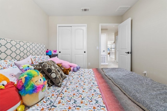 carpeted bedroom with visible vents and a closet