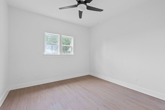 empty room featuring baseboards, a ceiling fan, and wood finished floors