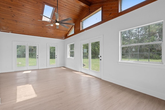 unfurnished living room with wood finished floors, a wealth of natural light, and high vaulted ceiling