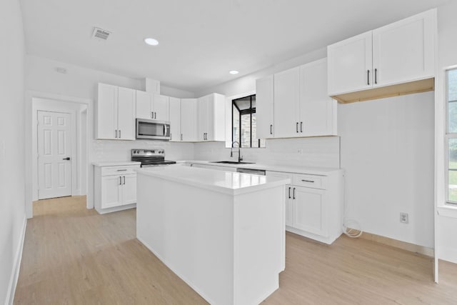 300 Fawn Ln, Georgetown, TX 78628 - kitchen featuring stainless steel appliances, light wood-type flooring, a kitchen island, healthy amount of natural light, and recessed lighting