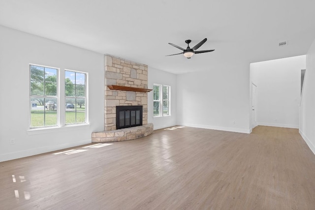 300 Fawn Ln, Georgetown, TX 78628 - unfurnished living room featuring light wood finished floors, ceiling fan, and a stone fireplace
