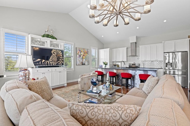 living room with a chandelier, baseboards, light wood-type flooring, recessed lighting, and high vaulted ceiling