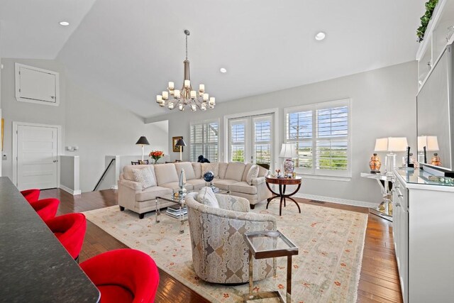 living room featuring recessed lighting, wood finished floors, an inviting chandelier, vaulted ceiling, and baseboards