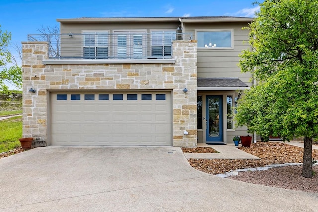 contemporary home with concrete driveway, an attached garage, and stone siding