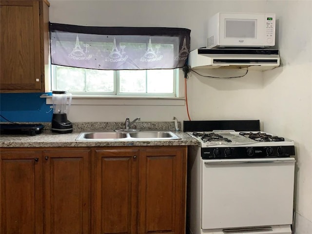 4811 Santa Anna St, Austin, TX 78721 - kitchen with range hood, brown cabinets, a sink, light countertops, and white appliances