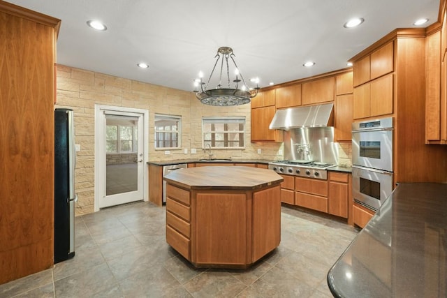 507 Arbors Cir, Elgin, TX 78621 - kitchen with ventilation hood, stainless steel appliances, butcher block counters, a center island, and a chandelier