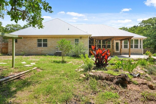507 Arbors Cir, Elgin, TX 78621 - back of house featuring a patio area, a metal roof, and stone siding