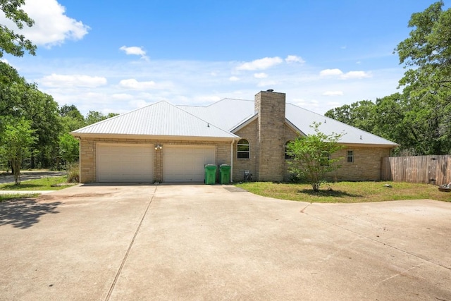 507 Arbors Cir, Elgin, TX 78621 - view of front of property with a chimney, a detached garage, and a metal roof