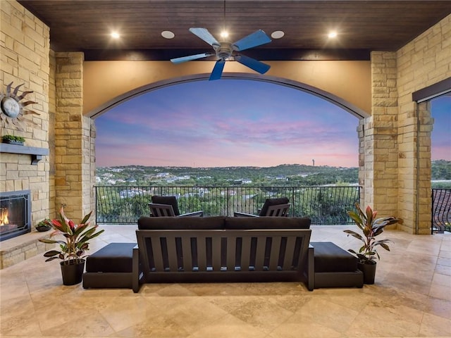 view of patio with ceiling fan and an outdoor living space with a fireplace