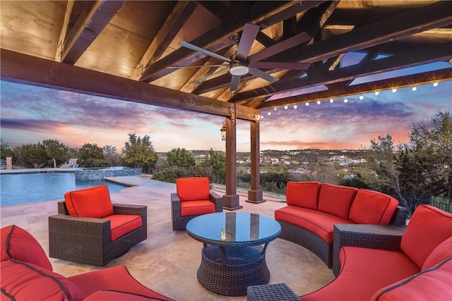 patio terrace at dusk featuring a ceiling fan, an infinity pool, and an outdoor living space