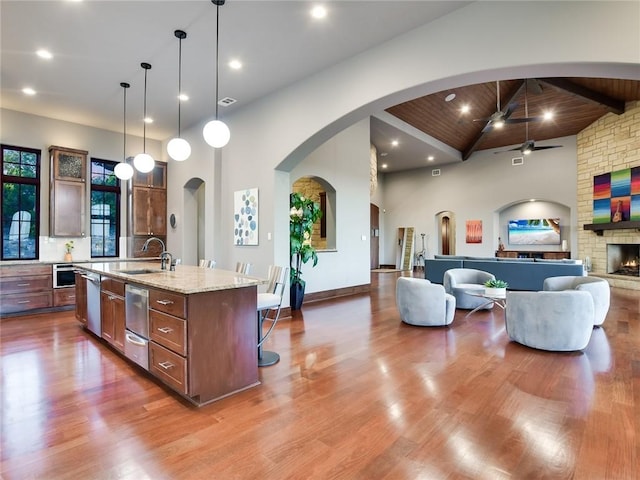 kitchen featuring dark wood finished floors, a ceiling fan, a kitchen breakfast bar, and a sink