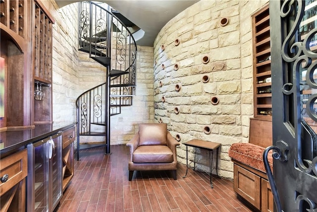 sitting room with beverage cooler, stairs, and dark wood-style flooring
