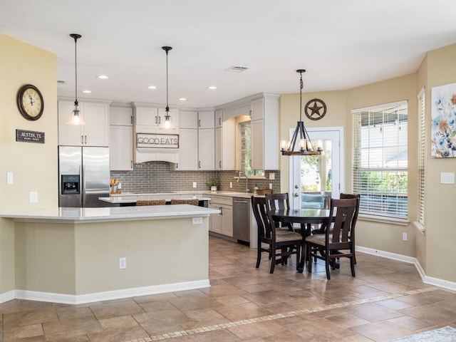 4525 Three Arrows Ct, Cedar Park, TX 78613 - kitchen featuring appliances with stainless steel finishes, baseboards, decorative backsplash, stone tile flooring, and a chandelier