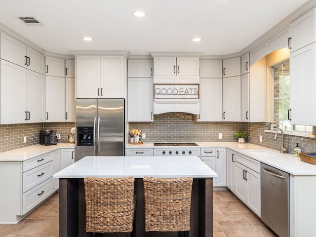 4525 Three Arrows Ct, Cedar Park, TX 78613 - kitchen with appliances with stainless steel finishes, a sink, decorative backsplash, a kitchen island, and recessed lighting