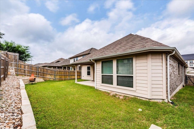 13305 Henneman Dr, Pflugerville, TX 78660 - back of property featuring a yard, a patio area, a fenced backyard, and roof with shingles