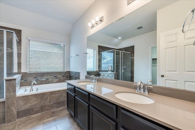 13305 Henneman Dr, Pflugerville, TX 78660 - bathroom with lofted ceiling, a garden tub, a stall shower, and a sink