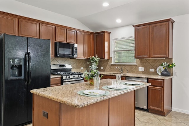 155 San Miniato St, Georgetown, TX 78628 - kitchen featuring black appliances, a sink, light stone countertops, lofted ceiling, and a center island