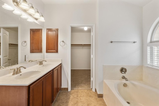 155 San Miniato St, Georgetown, TX 78628 - bathroom featuring a garden tub, double vanity, a walk in closet, and tile patterned floors