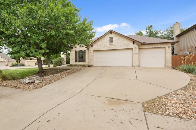 155 San Miniato St, Georgetown, TX 78628 - view of front facade with an attached garage, stone siding, and driveway