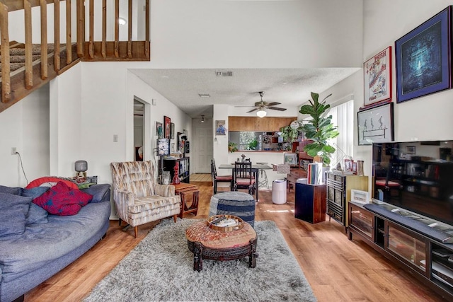 1515 W Braker Ln Unit A, Austin, TX 78758 - living room featuring light wood-type flooring, ceiling fan, and a towering ceiling
