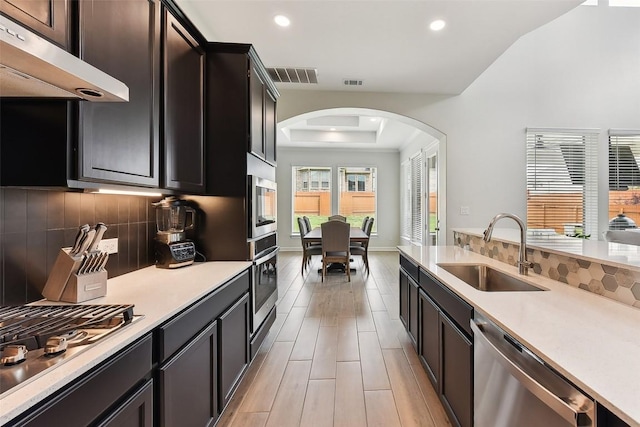361 Wild Pecan Loop, Buda, TX 78610 - kitchen featuring stainless steel appliances, arched walkways, under cabinet range hood, recessed lighting, and tasteful backsplash