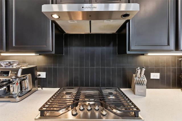 361 Wild Pecan Loop, Buda, TX 78610 - kitchen view of stainless steel gas stovetop, decorative backsplash, and range hood