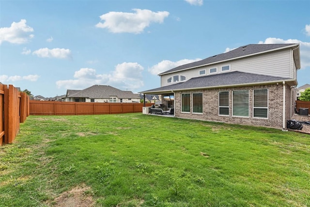 361 Wild Pecan Loop, Buda, TX 78610 - rear view of house with a fenced backyard, brick siding, and a patio