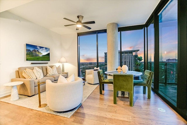 84 E Ave Unit 3909, Austin, TX 78701 - living area featuring a ceiling fan, a wall of windows, wood finished floors, and baseboards