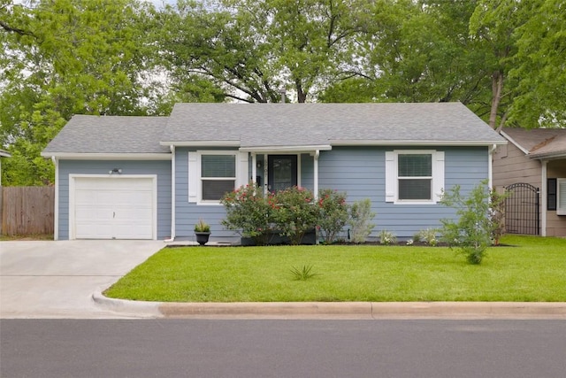 single story home featuring a front lawn, driveway, an attached garage, and fence