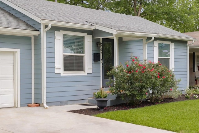 5707 Ave G, Austin, TX 78752 - view of exterior entry featuring roof with shingles and driveway