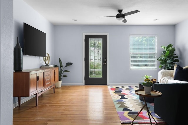 interior space with light wood finished floors, a ceiling fan, recessed lighting, and baseboards