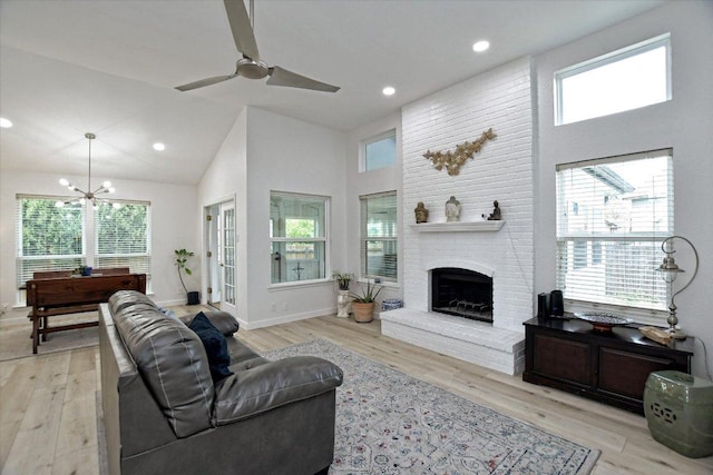 2208 Mimosa Trl, Round Rock, TX 78664 - living area featuring ceiling fan with notable chandelier, a fireplace, light wood finished floors, baseboards, and high vaulted ceiling