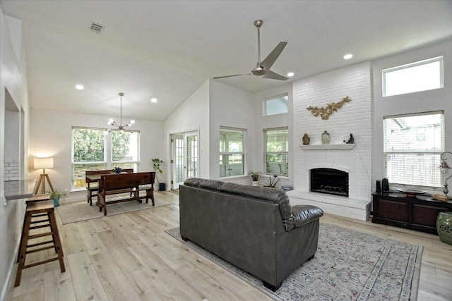 2208 Mimosa Trl, Round Rock, TX 78664 - living area featuring high vaulted ceiling, ceiling fan with notable chandelier, light wood-style flooring, and plenty of natural light