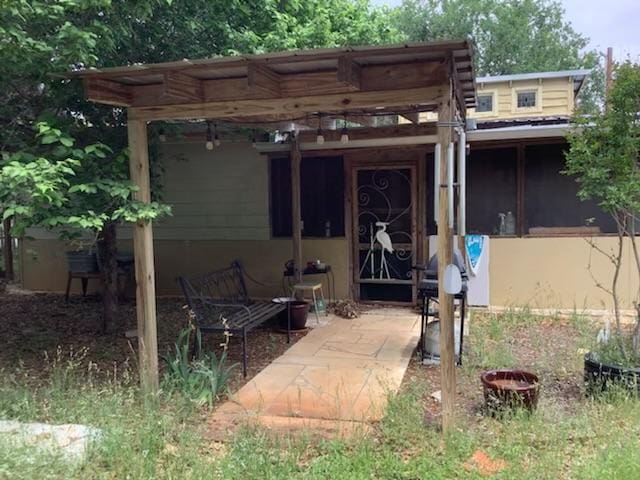 view of exterior entry featuring a pergola