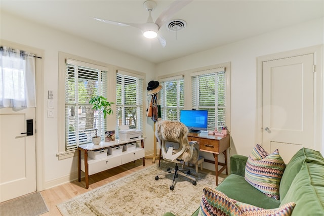office featuring visible vents, wood finished floors, a ceiling fan, and plenty of natural light