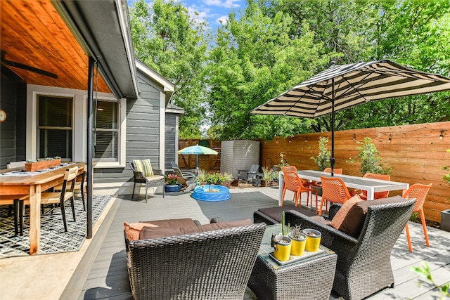 view of patio / terrace with outdoor dining area, a wooden deck, and a fenced backyard