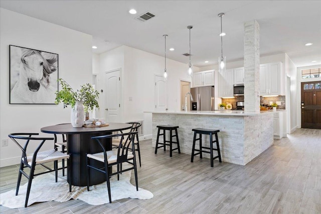 dining space featuring visible vents, recessed lighting, light wood-style floors, and baseboards