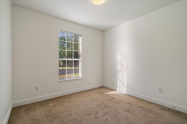 empty room featuring baseboards and carpet flooring