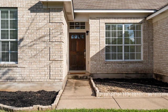 view of exterior entry with brick siding