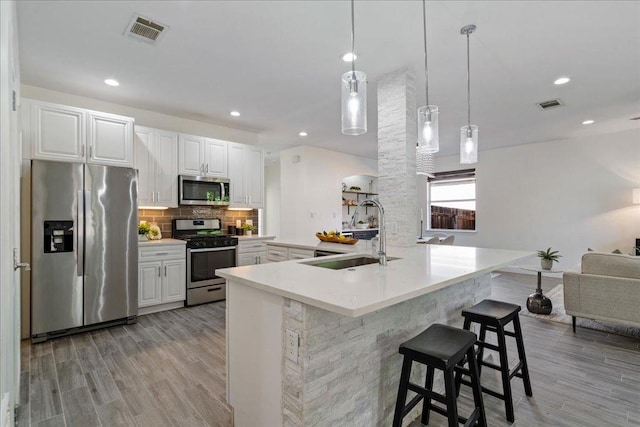 kitchen with visible vents, light wood-style floors, appliances with stainless steel finishes, and a sink